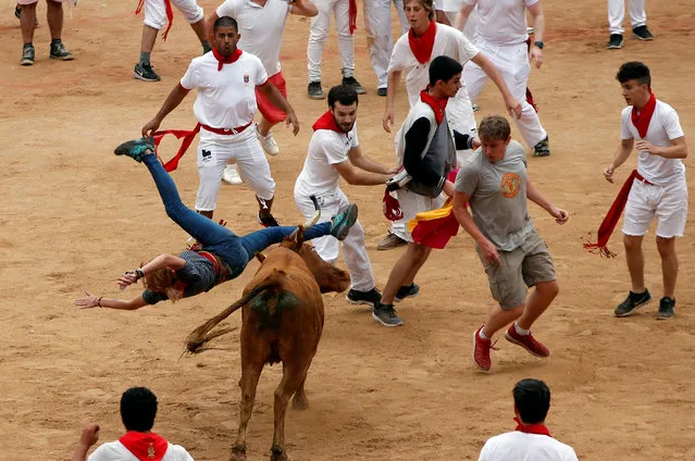 A wild cow charges at a reveller in the bullring following the fifth running of the bulls at the San Fermin festival in Pamplona, Spain July 11, 2017. (Photo by Susana Vera/Reuters)