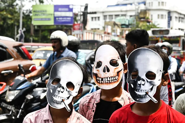 School children wear face masks as they take part in an awareness rally against the use of tobacco on “World No Tobacco Day” in Kolkata on May 31, 2022. (Photo by Dibyangshu Sarkar/AFP Photo)