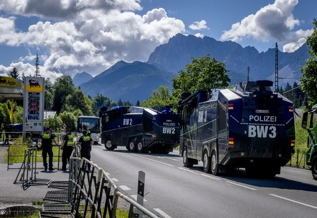 German police water canons approach a gas station to pick up gas in Klais near Elmau, Germany, Saturday, June 25, 2022. The G7 summit will start on Sunday. (Photo by Michael Probst/AP Photo)