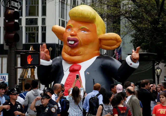 People looks at a giant inflatable rat in the likeness of U.S. President Donald Trump, displayed near Trump Tower in New York City, U.S., August 14, 2017. (Photo by Brendan McDermid/Reuters)