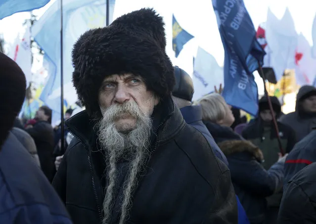A protester looks on during a rally in front of the parliament building to protest against changes to laws governing the sale of farmland, in Kyiv, Ukraine, Thursday, February 6, 2020. Scuffles broke out inside parliament as lawmakers debated changes to laws restricting sales of farmland. (Photo by Efrem Lukatsky/AP Photo)