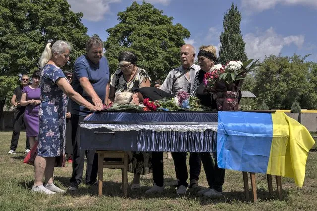 The mother of 40-year-old Volodymyr Miroshnychenko who was killed on the frontlines of Marinka, mourns during his funeral procession at a cemetery in Pokrovsk, eastern Ukraine, Friday, July 15, 2022. (Photo by Nariman El-Mofty/AP Photo)