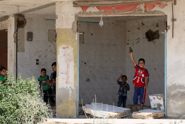 Boys play inside an empty shop in the rebel-held town of Dael, in Deraa Governorate, Syria July 7, 2016. (Photo by Alaa Al-Faqir/Reuters)