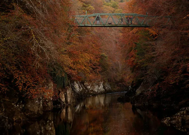 People walk on the bridge over the river Garry, Pitlochry, Scotland, Britain on October 26, 2019. (Photo by Russell Cheyne/Reuters)