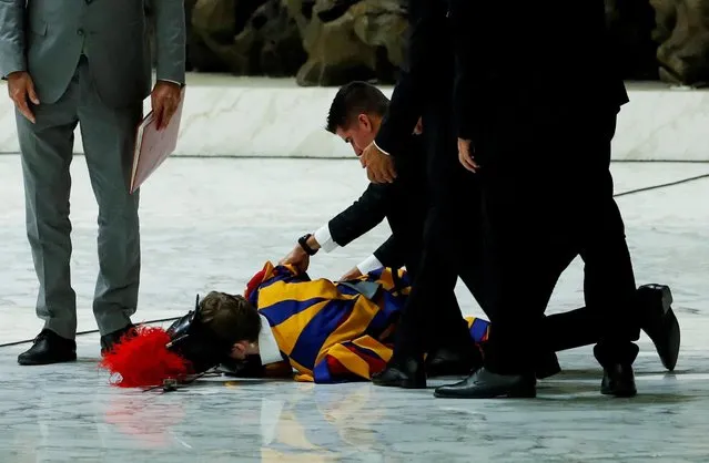 A Swiss guard faints as Pope Francis holds the weekly general audience at the Vatican on August 17, 2022. (Photo by Remo Casilli/Reuters)