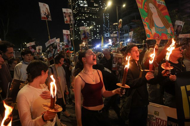 Supporters of Israeli hostages, who were kidnapped during the deadly October 7 2023 attack by Hamas, hold torches as they attend a protest to demand a deal to bring every hostage home at once, amid Gaza ceasefire negotiations, in Tel Aviv, Israel, on January 15, 2025. (Photo by Ronen Zvulun/Reuters)