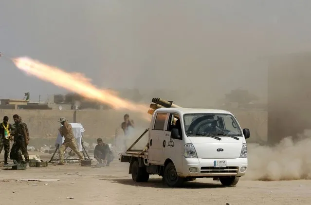 In this Wednesday, September 3, 2014 photo, Iraqi security forces and Shiite militiamen fire at Islamic State group positions during an operation outside Amirli, some 105 miles (170 kilometers) north of Baghdad, Iraq. (Photo by AP Photo/Stringer)