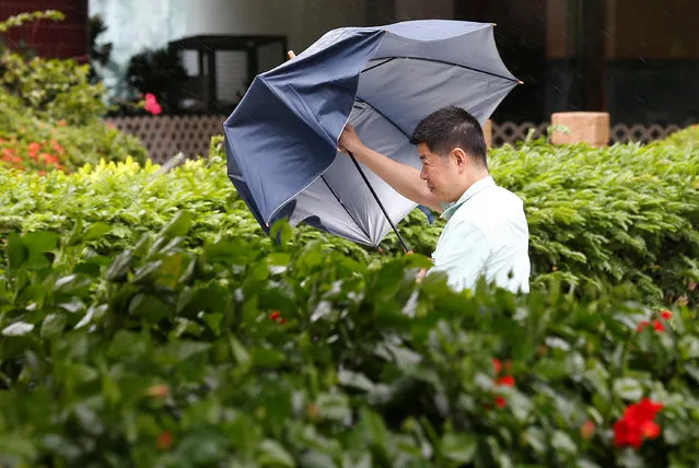 A man with an umbrella struggles in heavy winds as Typhoon Nida hits Hong Kong, China August 2, 2016. (Photo by Tyrone Siu/Reuters)