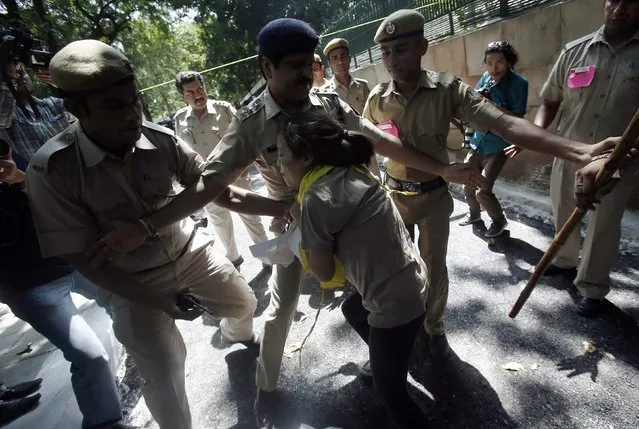 A Tibetan exile scuffles with police during a protest outside the venue of a meeting between China's President Xi Jinping and Indian Prime Minister Narendra Modi in New Delhi September 18, 2014. Groups of Tibetan activists held noisy protests outside the hotel where Xi was staying in New Delhi, and at the stately Hyderabad House where he sat down for formal talks with Modi. (Photo by Adnan Abidi/Reuters)