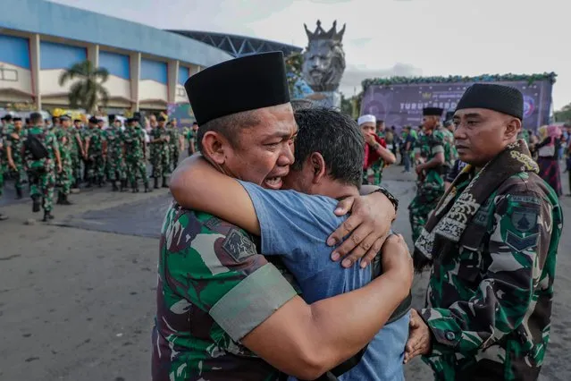 A soldier and a civilian hug each other during a mass prayer for the victims of a deadly stampede, outside Kanjuruhan Stadium in Malang, East Java, 04 October 2022. According to Indonesia's Coordinating Minister for Political, Legal and Security Affairs Mahfud MD, the government formed an independent investigation team after at least 125 people died during a riot and stampede following a soccer match between Arema FC and Persebaya Surabaya in East Java on 01 October 2022. (Photo by Mast Irham/EPA/EFE/Rex Features/Shutterstock)