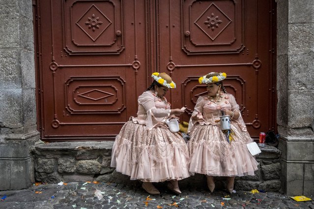 Two dancers rest during a folklore festival in La Paz, Bolivia, 02 December 2023. A parade with indigenous and folklore dances from Bolivia marked the beginning of the activities for the celebration of the Great Power festival which takes place in 2024. It will be five years since it was recognized as Intangible Cultural Heritage of Humanity and half a century of the association that organizes it. About 25 fraternities of folklorists demonstrated the most representative dances that are presented during the festival. (Photo by Esteban Biba/EPA/EFE)
