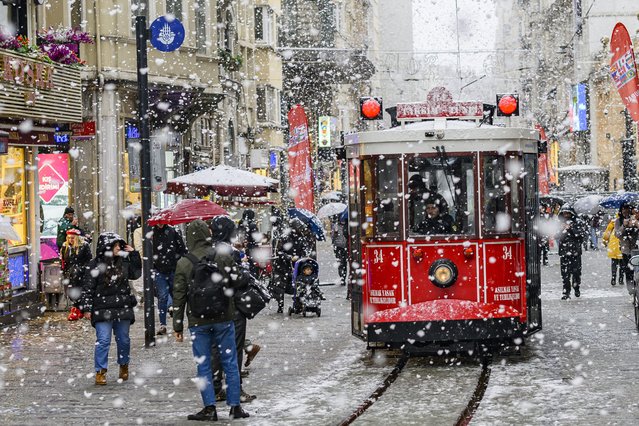 A tram runs under the falling snow along Istiklal Avenue, in Istanbul on February 19, 2025. (Photo by Yasin Akgul/AFP Photo)