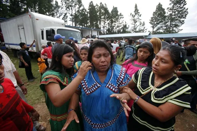An Indigenous woman is reacts after coming in contact with tear gas during a protest at a signing ceremony for the reactivation of a hydroelectric project in Llano Tuguri, Ngabe Bugle, Panama, 22 August 2016. Indigenous groups, protesting against the hydroelectric project, threw stones at the school were the signing ceremony took place, injuring four policemen. The groups refused to let President of Panama, Juan Carlos Varela, leave the school until he signed an agreement with the leaders of the Ngabe Bugle region. The project will continue but will be operated by a third independent party and not the company that built it, according to an agreement signed on the same day between the Panamanian government and five leaders of the Ngabe Bugle region. (Photo by Alejandro Bolivar/EPA)