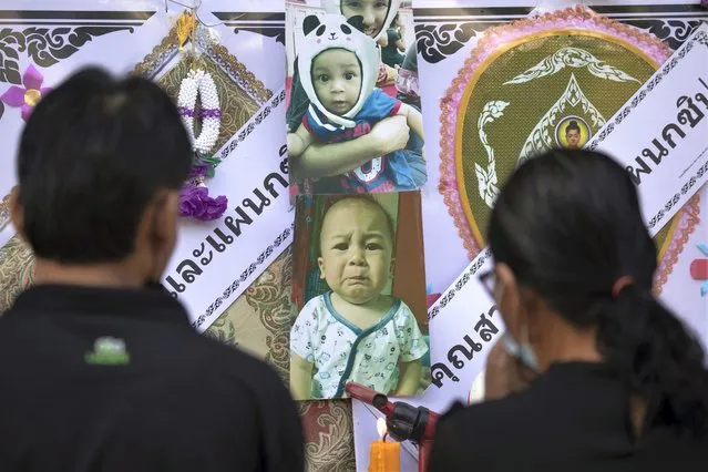 Visitors pay their respects at a memorial for the victims of a mass killing attack outside Wat Rat Samakee temple in Uthai Sawan, north eastern Thailand, Sunday, October 9, 2022. A former police officer burst into a day care center in northeastern Thailand on Thursday, killing dozens of preschoolers and teachers before shooting more people as he fled. (Photo by Wason Wanichakorn/AP Photo)