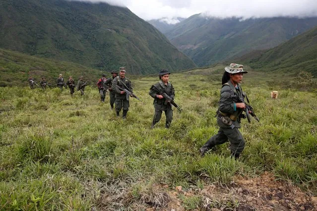 Members of the 51st Front of the Revolutionary Armed Forces of Colombia (FARC) patrol in the remote mountains of Colombia, August 16, 2016. (Photo by John Vizcaino/Reuters)