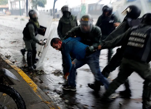 Riot security forces detain a demonstrator during a rally against Venezuela's President Nicolas Maduro's government in Caracas, Venezuela, July 28, 2017. Rock-throwing Venezuelans braved tear gas and rainstorms, blocking streets in protest against a legislative super-body to be elected two days later that critics call an attempt by President Nicolas Maduro to create a dictatorship. Carlos Garcia Rawlins: “After many hours of very violent clashes between the demonstrators and security forces, the National Guard in an attempt to end the situation, suddenly advanced their line very quickly, even going beyond where I and other photographers were taking cover. All the protesters who did not react fast enough to leave the place were detained”. (Photo by Carlos Garcia Rawlins/Reuters)