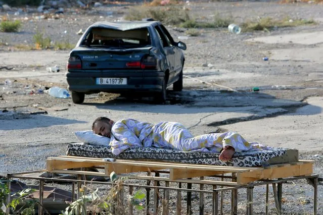 A man sleeps near a damaged car near the site of Tuesday's blast in Beirut's port area, Lebanon on August 6, 2020. (Photo by Aziz Taher/Reuters)