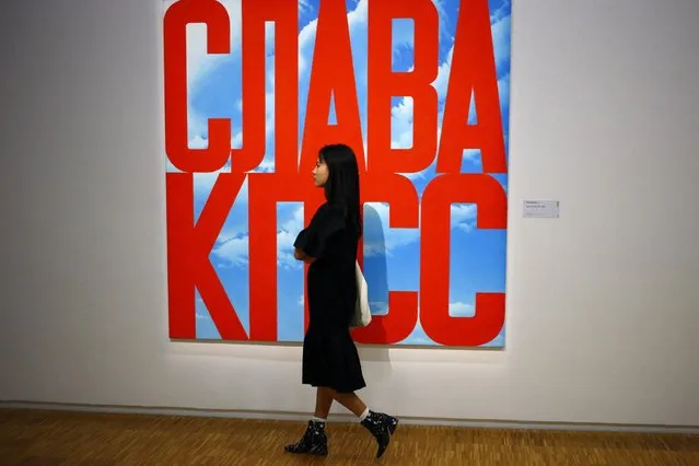 In this photo dated Monday, September 12, 2016 a visitor passes by an oil painting “Gloire au PCUS, 2003-2005” by Erik Bulatov (1933) during the presentation of the Kollektsia exhibition dedicated to Russian contemporary art at Beaubourg Museum in Paris, France. (Photo by Francois Mori/AP Photo)