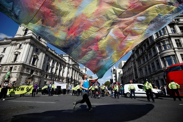An Extinction Rebellion climate activist waves a large flag during a “peaceful disruption” of British Parliament as lawmakers return from the summer recess, in London, Britain on September 1, 2020. (Photo by Henry Nicholls/Reuters)