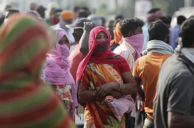 Migrant laborers from other states looking for work gather on a street on the outskirts of Jammu, India, Sunday, September 27, 2020. The nation of 1.3 billion people is expected to become the coronavirus pandemic's worst-hit country within weeks, surpassing the United States. (Photo by Channi Anand/AP Photo)