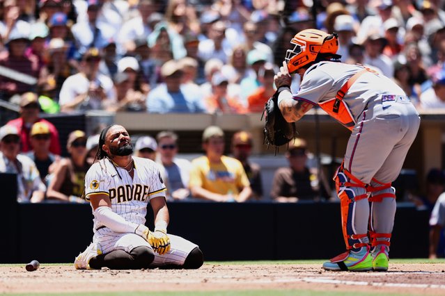 San Diego Padres' Fernando Tatis Jr., left, reacts after being hit by a pitch as New York Mets catcher Francisco Alvarez looks on during the second inning of a baseball game, Wednesday, July 30, 2025, in San Diego. (Photo by Derrick Tuskan/AP Photo)