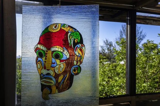 A painting by French-born artist Delphine Poulain hangs inside her home in Hanga Roa, Rapa Nui, or Easter Island, Chile, Wednesday, November 23, 2022. Poulain work begins with sketches on a blank sheet. Then she takes her images to the canvas with acrylic paint. (Photo by Esteban Felix/AP Photo)