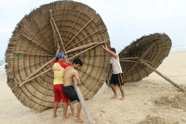 People remove beach cabanas ahead of Typhoon Molave in Danang, Vietnam on Monday, October 26, 2020. (Photo by Tran Le Lam/VNA via AP Photo)