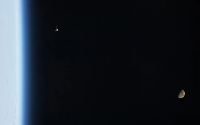 As the ISS and Soyuz TMA-07M spacecraft were making their relative approaches on December 21, one of the Expedition 34 crew members on the orbital outpost captured this photo of the Soyuz (upper left) and a gibbous moon (lower right). (Photo by NASA/The Atlantic)