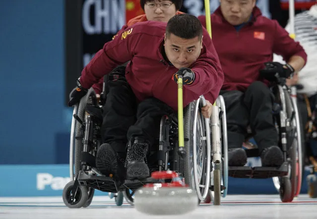 China's Wang Haitao throws the stone  during the Wheelchair Curling Round Robin Session against South Korea at the Gangneung Curling Centre in Gangneung at the Paralympic Winter Games, South Korea, Thursday, March 15, 2018. (Photo by Simon Bruty/OIS/IOC via AP Photo)