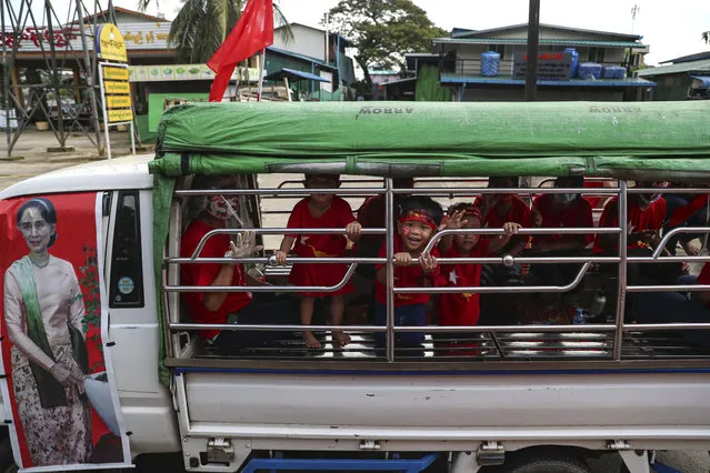 Children wearing T-shirt cheer on a truck carrying an image of Myanmar Leader Aung San Suu Kyi as her supporters make an election campaign for the National League for Democracy (NLD), ahead of next month's general election Sunday, October 25, 2020, on the outskirts Yangon, Myanmar. (Photo by Thein Zaw/AP Photo)
