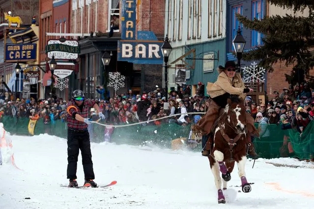 Rider Janelle Urista pulls skier Darrin Anderson down Harrison Avenue during the 75th annual Leadville Ski Joring weekend competition in Leadville, Colorado on March 4, 2023. Skijoring, which has its origins as a competitive sport in Scandinavia, has been adapted over the years to include a team made up of a rider and skier who must navigate jumps, slalom gates, and the spearing of rings for points. Leadville, with an elevation of 10,152 feet (3,094 m), the highest incorporated city in North America, has been hosting skijoring competitions since 1949. (Photo by Jason Connolly/AFP Photo)