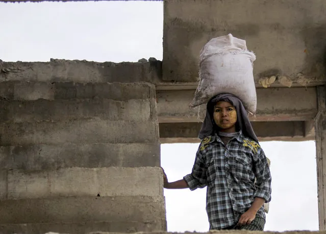 A Myanmar girl transports a bag of sand on her head as she works at a construction site near the bank of the Irrawaddy River in Mandalay, Myanmar, 07 October 2015. The World Bank forecasts Myanmar economy growth rate would slow down 6.5 percent caused by nationwide floods, investments and country's political challenges ahead of general election despite it first predicted as 8.2 percent to growth in this fiscal year 2015-2016. (Photo by Hein Htet/EPA)