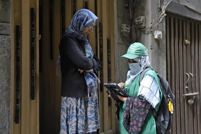 A government worker collects data from a woman during census, in Lahore, Pakistan, Wednesday, March 1, 2023. Pakistan on Wednesday launched its first-ever digital population and housing census to gather demographic data on every individual ahead of the parliamentary elections which are due later this year, officials said. (Photo by K.M. Chaudary/AP Photo)