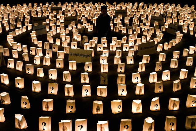 A boy sits in the middle of a circle of candles that commemorate those who went missing during the1998-99 Kosovo war, in Pristina, Kosovo, on April 26, 2013. International agencies estimate that over a thousand people remain missing in Kosovo. (Photo by Visar Kryeziu/Associated Press)