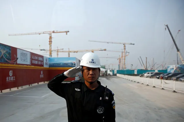A security officer salutes at the entrance to the construction site of the terminal for the Beijing New Airport in Beijing's southern Daxing District, China, October 10, 2016. (Photo by Thomas Peter/Reuters)