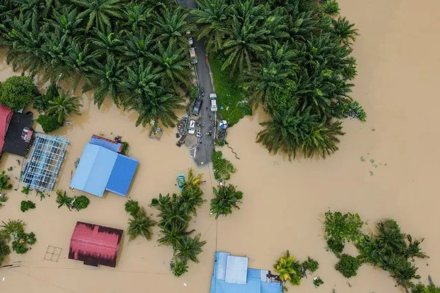 An aerial view shows a flooded road next to submerged houses in Yong Peng, Malaysia's Johor state, on March 4, 2023. At least four people have died and nearly 41,000 evacuated in Malaysia after floodwaters caused by “unusual” torrential rains lasting days swept through several states, officials said March 4. (Photo by Mohd Rasfan/AFP Photo)
