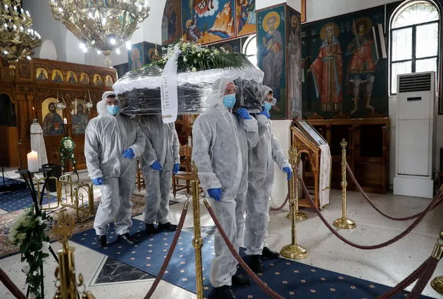Pallbearers, wearing personal protective equipment (PPE), carry the coffin of a patient who died from the coronavirus disease (COVID-19), inside a church in Athens, Greece, December 2, 2020. (Photo by Giorgos Moutafis/Reuters)