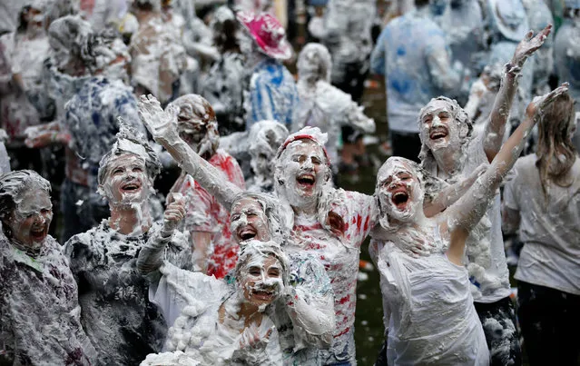 Students from St Andrew's University indulge in a tradition of covering themselves with foam to honour the “academic family” on October 17, 2015, in St Andrews, Scotland. Every year the “raisin weekend” which is held in the university's Lower College Lawn, is celebrated and a gift of raisins (now foam) is traditionally given by first year students to their elders as a thank you for their guidance and in exchange they receive a receipt in Latin. (Photo by Jane Barlow/PA Wire)