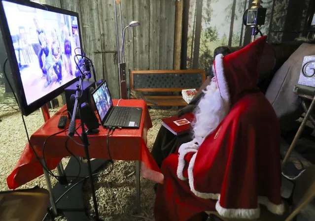 A person dressed as Samichlaus (Swiss Santa) interacts with children via video at a studio of the St. Nikolausgesellschaft Zurich, as the spread of the coronavirus continues, in Zurich, Switzerland on December 4, 2020. (Photo by Arnd Wiegmann/Reuters)