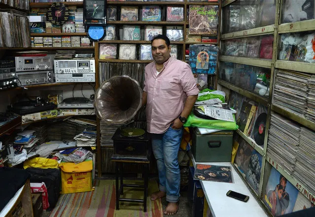 Syed Zafar Shah, 40, who runs a gramophone repair operation, poses at the Shah Music Centre store where he sells antique gramophones and vinyl records in the old quarters of New Delhi on April 24, 2018. Gramophone record players emerged as the primary way to replay audio recordings in the late 19 th century, amplifying the grooves in vinyl disks, but was steadily overtaken in the 20 th century by turntables playing records connected to electrified audio speakers. (Photo by Sajjad Hussain/AFP Photo)