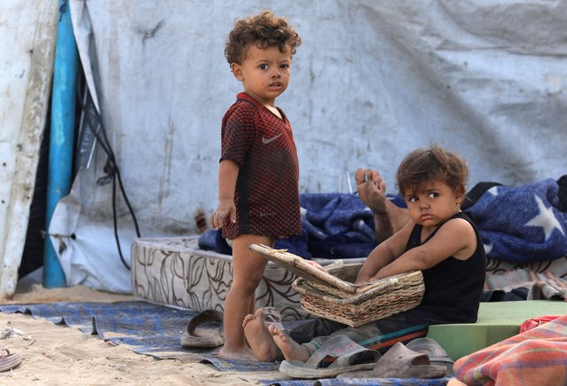 Displaced Palestinian children shelter on the side of a raod, after Hamas agreed to release hostages and accept some other terms in a U.S. plan to end the war, in the central Gaza Strip, on October 4, 2025. (Photo by Dawoud Abu Alkas/Reuters)