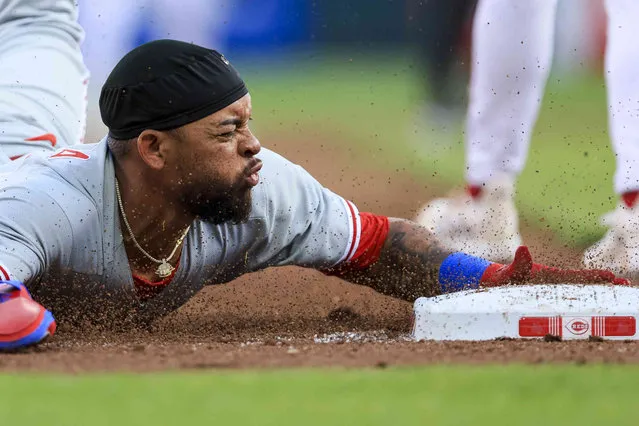 Philadelphia Phillies' Edmundo Sosa slides safely into third base after a single by Cristian Pache during the first inning of a baseball game against the Cincinnati Reds in Cincinnati, Thursday, April 13, 2023. (Photo by Aaron Doster/AP Photo)