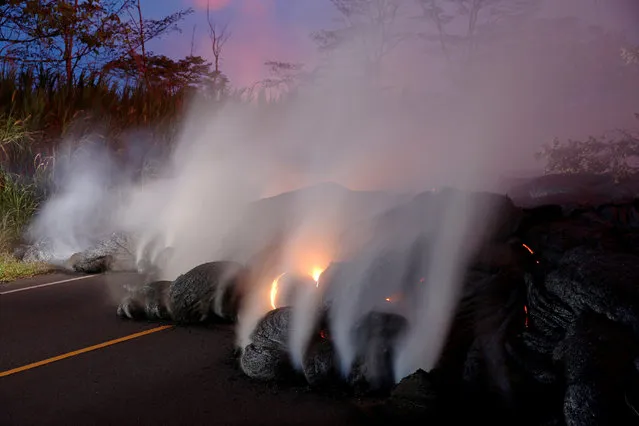 Volcanic gases rise from the Kilauea lava flow that crossed Pohoiki Road near Highway 132, near Pahoa, Hawaii, May 28, 2018. (Photo by Marco Garcia/Reuters)