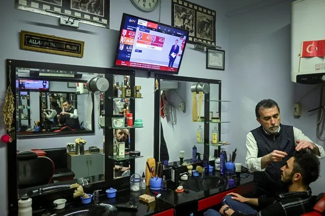 A man watches the news as he gets a haircut at his local barber's, following presidential and parliamentary election, in Istanbul, Turkey on May 15, 2023. (Photo by Dylan Martinez/Reuters)
