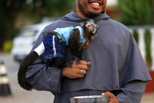 A monkey named Miguel poses for a photo with a Franciscan during a mass in honor of Saint Francis of Assisi on the Saint’s feast day in Brasilia, Brazil, on October 4, 2024. (Photo by Ueslei Marcelino/Reuters)