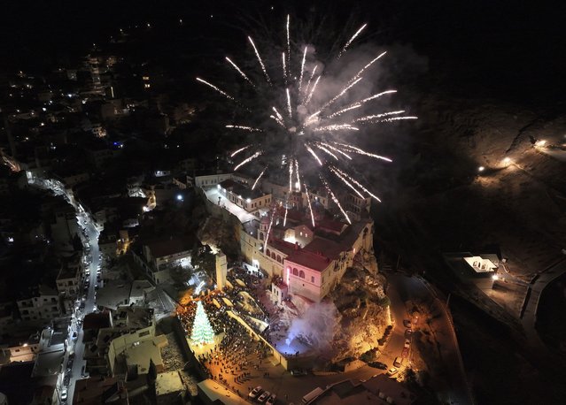 Fireworks burst over Saydnaya Convent during the lighting of the Christmas tree, in Saydnaya, on the outskirts of Damascus, Syria, December 24, 2024. (Photo by Hussein Malla/AP Photo)