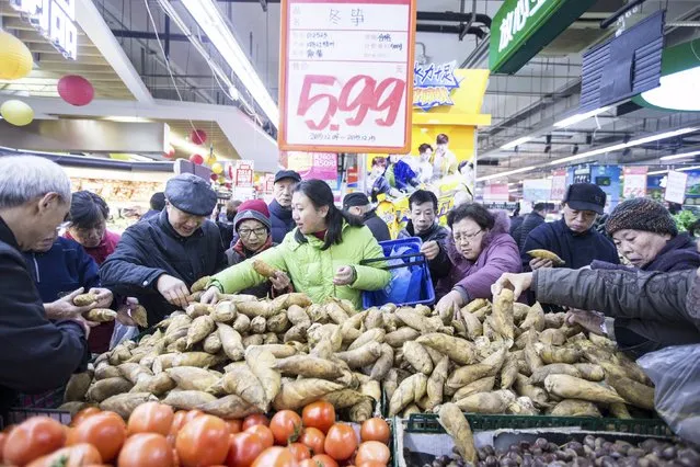Customers crowd to buy bamboo shoots at a supermarket on the “Double 12” shopping festival in Hangzhou, Zhejiang province, China, December 12, 2015. Many supermarkets in China cooperated with Alipay, the online payment platform of Alibaba Group, on this festival to offer their customers 50% off up to 50 yuan ($7.74), local media reported. Alipay's wallet system is widely used in both retail shops and for online transactions. (Photo by Reuters/Stringer)