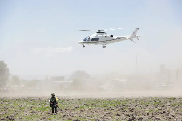 A soldier keeps watch near the site damaged due to fireworks explosions as a helicopter hovers in the municipality of Tultepec, on the outskirts of Mexico City, Mexico July 5, 2018. At least 24 people were killed in a series of explosions Thursday at fireworks warehouses in the town of Tultepec in central Mexico, including rescue workers who died saving others' lives, officials said. (Photo by Daniel Becerril/Reuters)