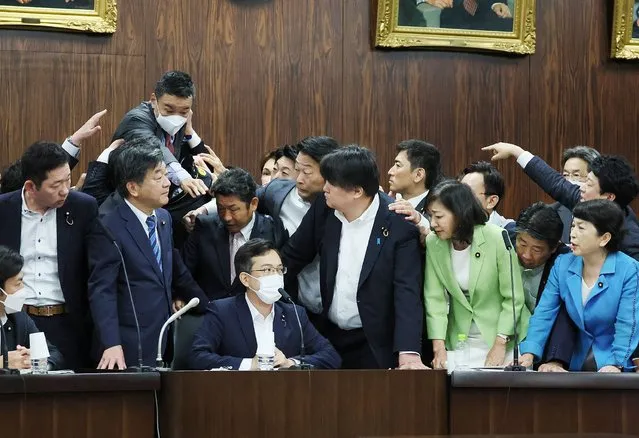 This photo taken on June 8, 2023 shows Japanese opposition lawmaker Taro Yamamoto (top L) trying to jump toward committee chairman Hisatake Sugi (seated centre L) as ruling coalition lawmakers push a controversial immigration bill to a vote, during an Upper House Judicial Affairs Committee meeting in Tokyo. Japan on June 9 enacted an immigration law that the government says will improve conditions for asylum seekers but that also allows it to deport those whose applications fail repeatedly. (Photo by JIJI Press via AFP Photo)