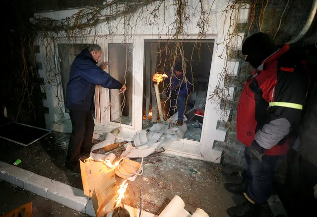 Men attack a building, which according to participants houses an office of Ukrainian politician and businessman Viktor Medvedchuk, during a rally held by activists of nationalist groups and their supporters who mark the anniversary of the 2014 Ukrainian pro-European Union (EU) mass protests on the Day of Dignity and Freedom in Kiev, Ukraine, November 21, 2016. (Photo by Valentyn Ogirenko/Reuters)